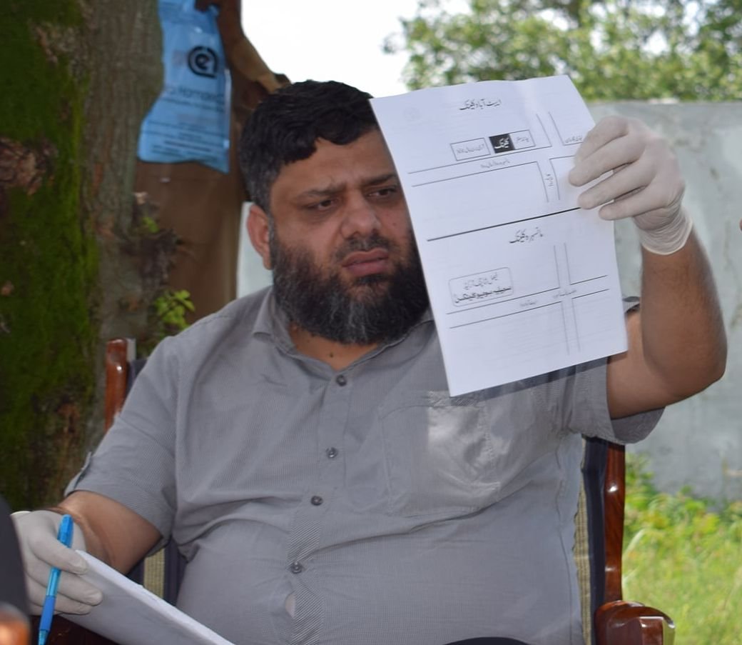 Dr. Ahmed Ejaz reviewing a plan at an outdoor free medical camp